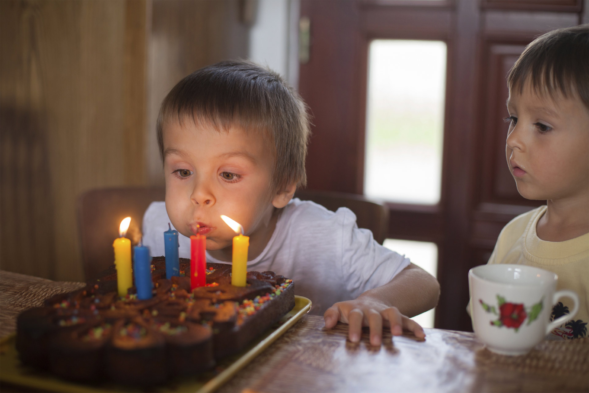 Un tierno niño intenta apagar la vela de su ponqué de cumpleaños, pero parece que tiene problemas. Sin embargo, una herramienta lo ayuda