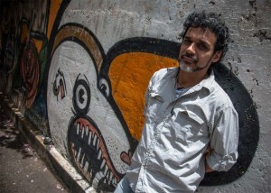 Héctor Torres posa junto al grafiti que sirvió de portada a Caracas Muerde